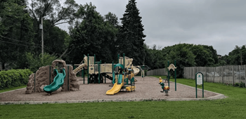 A playground with a green slide and a yellow slide.